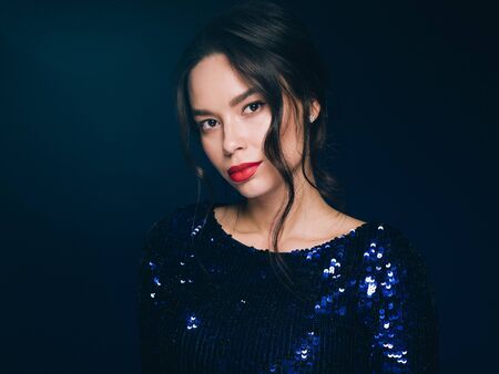 Woman in sequin dress night club concept red lips asian beauty. Studio shot.の写真素材