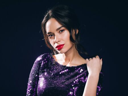 Woman in sequin dress night club concept red lips asian beauty. Studio shot.の写真素材
