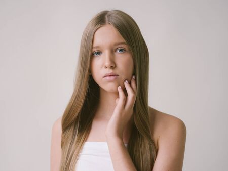 Long smooth hair clean skin girl healthy skin care natural makeup female portrait isolated on white. Studio shot.の写真素材