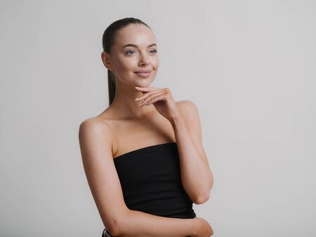 Woman natural makeup teeth smile  beautiful female portrait young beauty model shoulders tanned skin. Studio shot.の写真素材