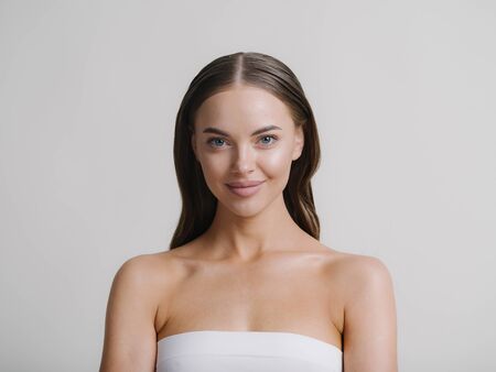 Natural beauty woman with heands touching face long brunette hair beautiful neck and shoulders. Studio shot.の写真素材