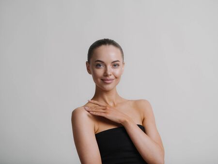 Woman natural makeup teeth smile  beautiful female portrait young beauty model shoulders tanned skin. Studio shot.の写真素材