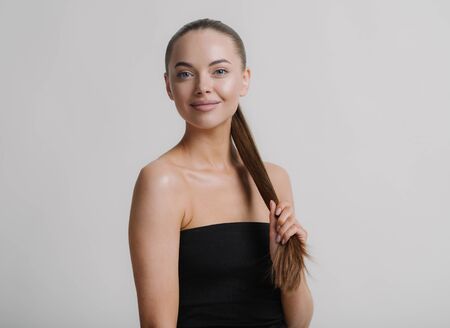 Woman natural makeup teeth smile  beautiful female portrait young beauty model shoulders tanned skin. Studio shot.の写真素材