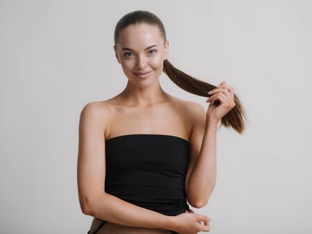 Woman natural makeup teeth smile  beautiful female portrait young beauty model shoulders tanned skin. Studio shot.の写真素材