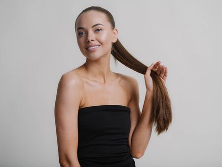 Woman natural makeup teeth smile  beautiful female portrait young beauty model shoulders tanned skin. Studio shot.の写真素材