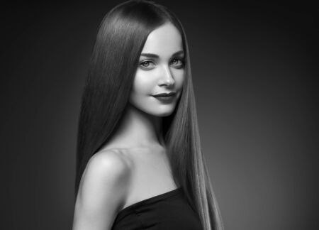 Beautiful hair woman long smooth brunette hairstyle beauty healthy hair female model portrait.  Studio shot. Monochrome. Gray. Black and white.の写真素材
