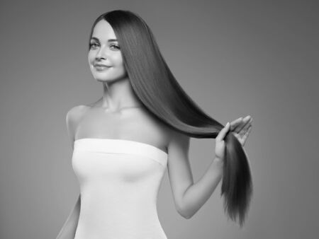 Beautiful hair woman long smooth hairstyle beauty concept. Studio shot. Monochrome. Gray. Black and white.の写真素材