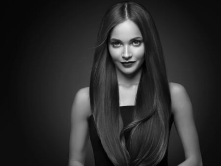 Beautiful hair woman long smooth brunette hairstyle beauty healthy hair female model portrait.  Studio shot. Monochrome. Gray. Black and white.の写真素材