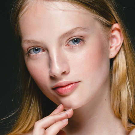 Beautiful Blonde Woman Beauty Model Girl with perfect makeup and hairstyle over black background.の写真素材