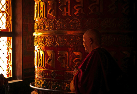 Monk Rotating a Prayer Wheel