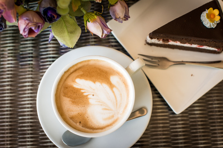 Cappuccino coffee cup ,Hot coffee and Chocolate cake on a white plate.の写真素材