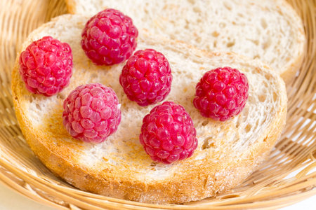 Berries of raspberry lie on slices of the dried bread