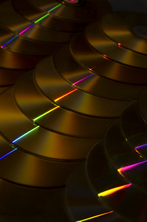 Horizontally stacked CDs with golden light.の写真素材