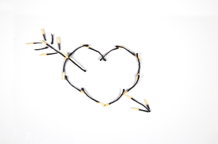 Burnt matches, laid with heart-shaped, represent a lost love.の写真素材