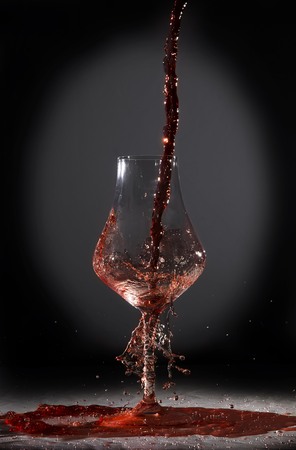 Wine incautiously poured into crystal goblet.の写真素材