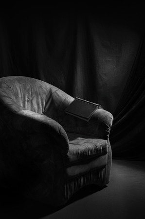 Old chair and a book in a dark room.の写真素材