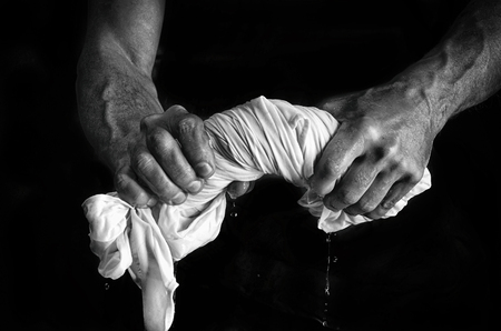 Strong men's hands squeeze washed laundry.の写真素材