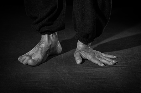 The man stands on one arm and one leg.の写真素材