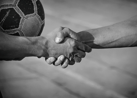 Friendly handshake opponents after a football match.