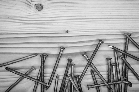 Old nails on a wooden table in black and white.の写真素材