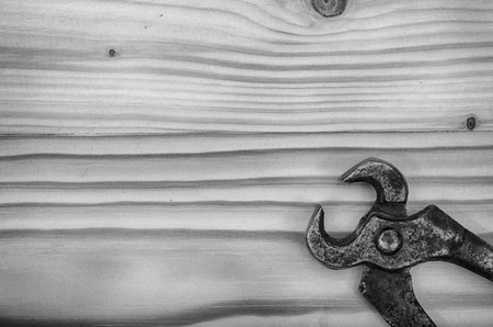 Old metal pliers on a wooden table in black and white.の写真素材