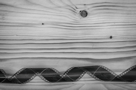 Old photo film on a wooden table in black and white.の写真素材