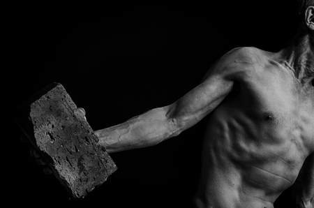 A protesting man throws a brick in black and white.の写真素材