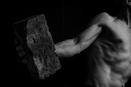 A protesting man throws a brick in black and white.の写真素材