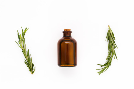 fresh rosemary with oil bottle on white backgroundの写真素材