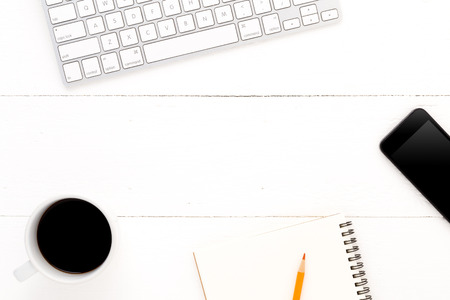Modern workplace with a cup of coffee, computer keyboard, note book, pencil and smartphone. copy spaceの写真素材