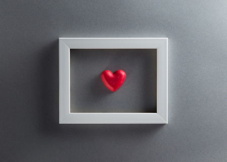 Valentines Day background with red chocolates heart shape and white frame from top view. Copy spaceの写真素材