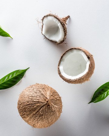 Tropical fruit whole and half abstract background .Coconut with green leaf on white background. from top viewの写真素材