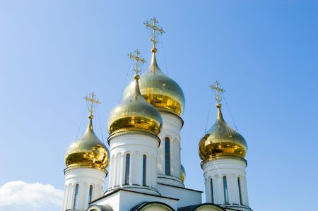 Golden church domes on blue sky background の写真素材