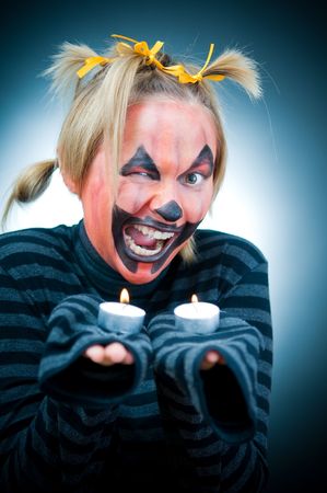 Funny Halloween girl with candles, focus on faceの写真素材