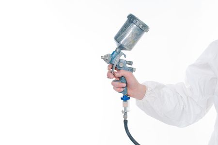 Worker holding airbrush gun over white background の写真素材