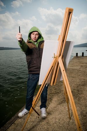 Young artist drawing outdoors in stormy weather  の写真素材