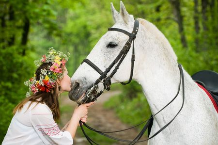 Cute girl with horse in the forest の写真素材