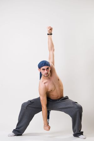 Young athletic dancer exercising, studio shot 
