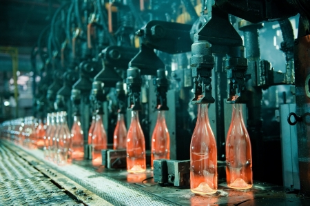 Row of hot orange glass bottles in factory の写真素材