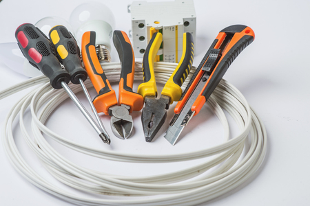 A set of tools electrician, a coil of wire and equipment on a white background