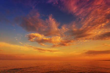 Beautiful sunset, dawn, over the sea, ocean, against the background of the blue sky and colorful cloudsの写真素材