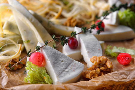 Sliced assorted cheese, mozzarella, camembert, brie, parmesanの写真素材