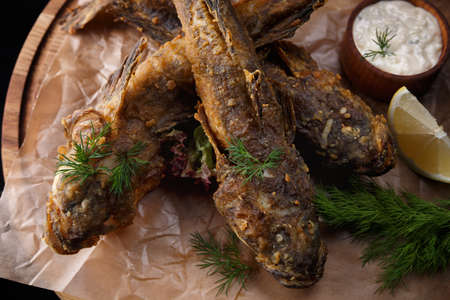 Fried fish goby (Gobiidae) with sauce on a wooden boardの写真素材