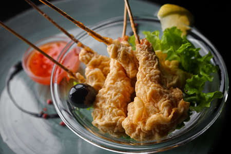 Shrimp in tempura on a white plate, on a dark backgroundの写真素材
