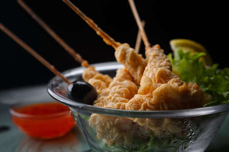 Shrimp in tempura on a white plate, on a dark backgroundの写真素材