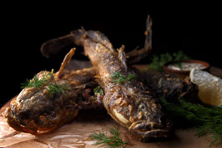 Fried fish goby (Gobiidae) with sauce on a wooden board