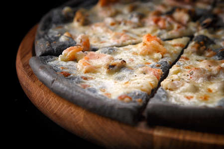 Black pizza on a wooden boardの写真素材