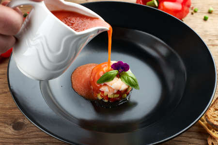 Gazpacho cold soup with shrimp on a black plateの写真素材