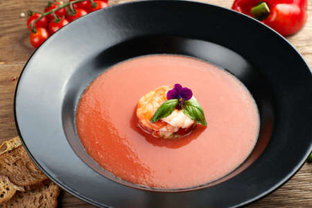 Gazpacho cold soup with shrimp on a black plateの写真素材