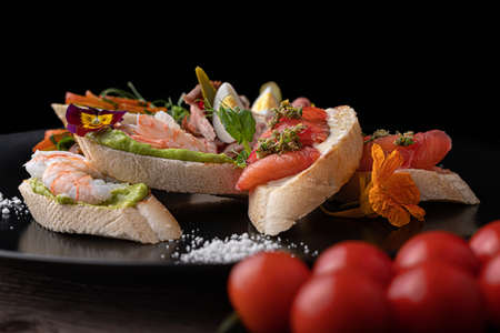 Brusquettes, Assorted, Fish, Prawns, Meat, Vegetables, Seafood, on a black backgroundの写真素材
